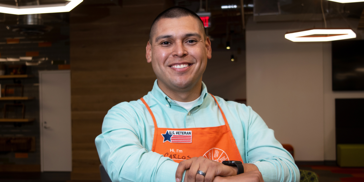 A man wearing a Home Depot apron smiling