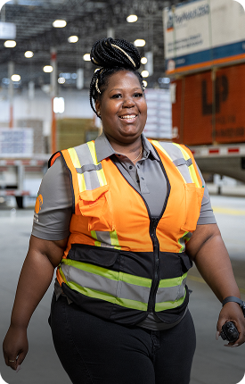 Woman in an orange safety vest, smiling.