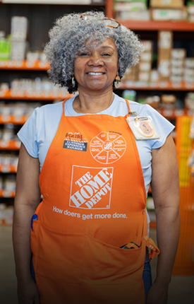 Woman in an orange Home Depot apron, smiling